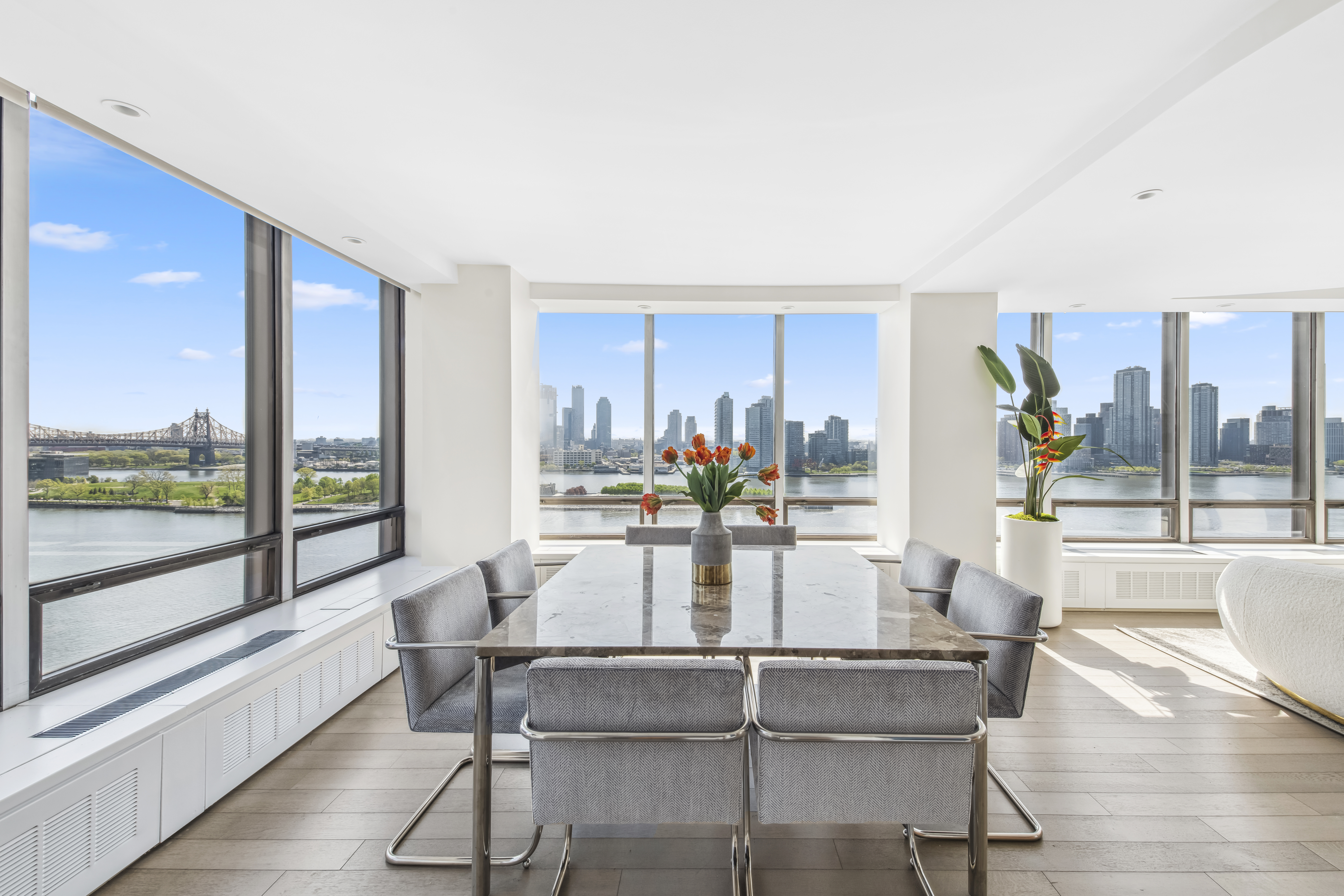 870 United Nations Plaza, Unit 15E Manhattan, NY 10017 - Photo 15 of 19 a view of a dining room with furniture large windows and wooden floor