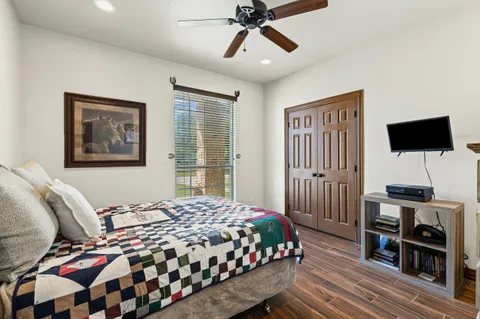 a bedroom with a bed a dresser and wooden floor
