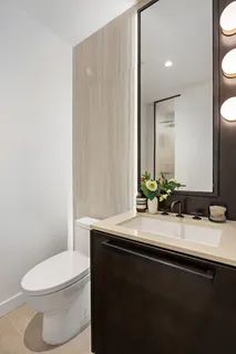 a bathroom with a sink a toilet and mirror