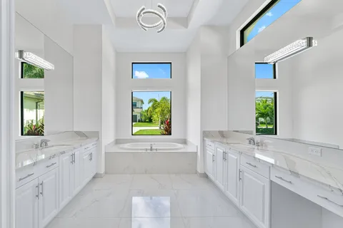 a bathroom with a granite countertop bathtub a sink and a window
