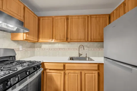 a kitchen with granite countertop a sink a stove and cabinets