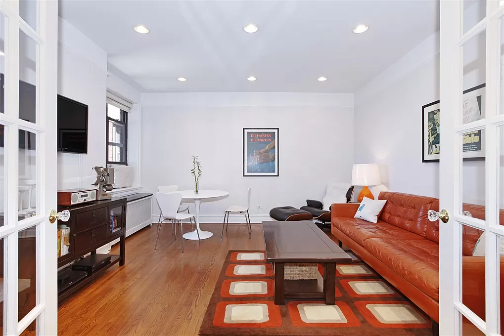 690 Riverside Drive, Unit 5C Manhattan, NY 10031 - Photo 2 of 12 a living room with furniture a flat screen tv and kitchen view