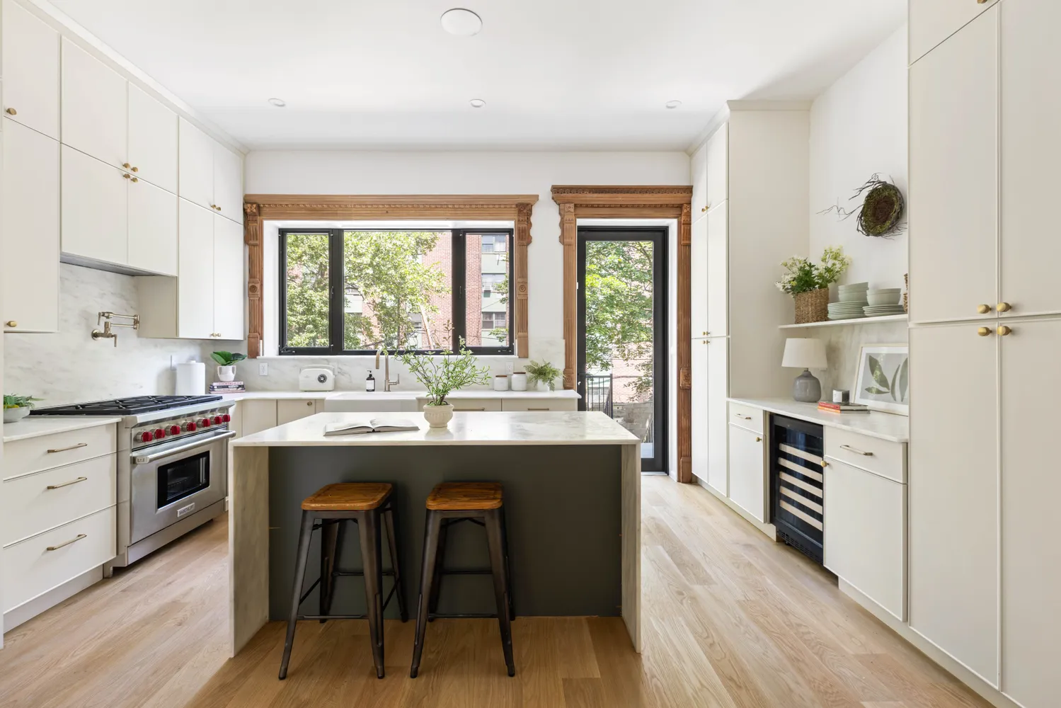 a kitchen with kitchen island a stove a sink a dining table and chairs