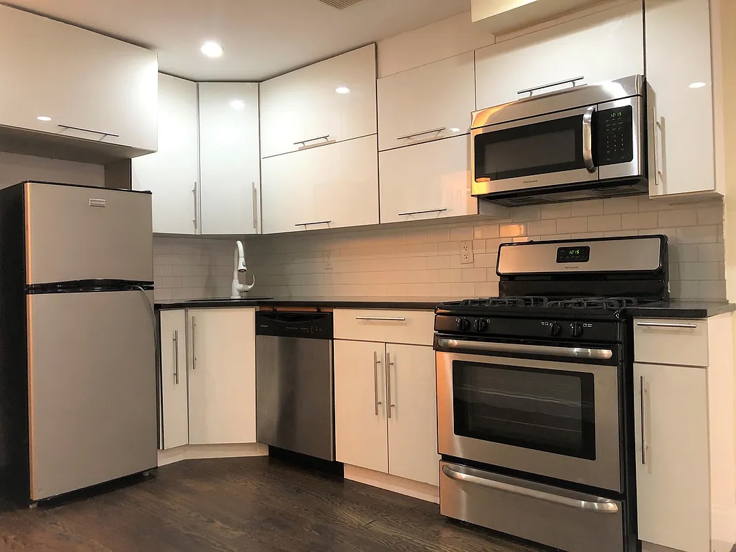 313 Van Buren Street Brooklyn, NY 11221 - Photo 6 of 20 a kitchen with stainless steel appliances granite countertop a stove microwave and refrigerator