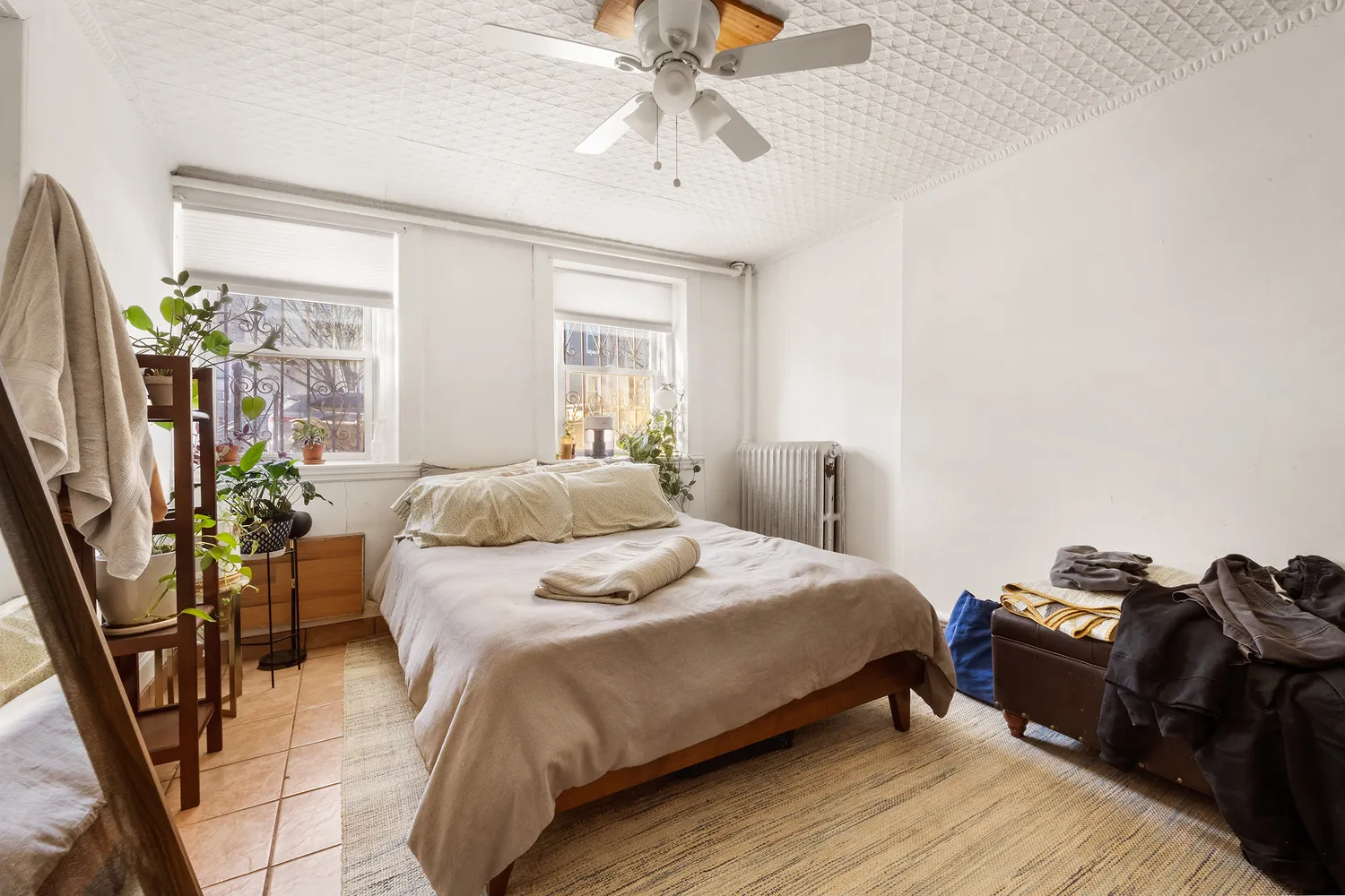 a bedroom with a bed flat screen tv and a large window