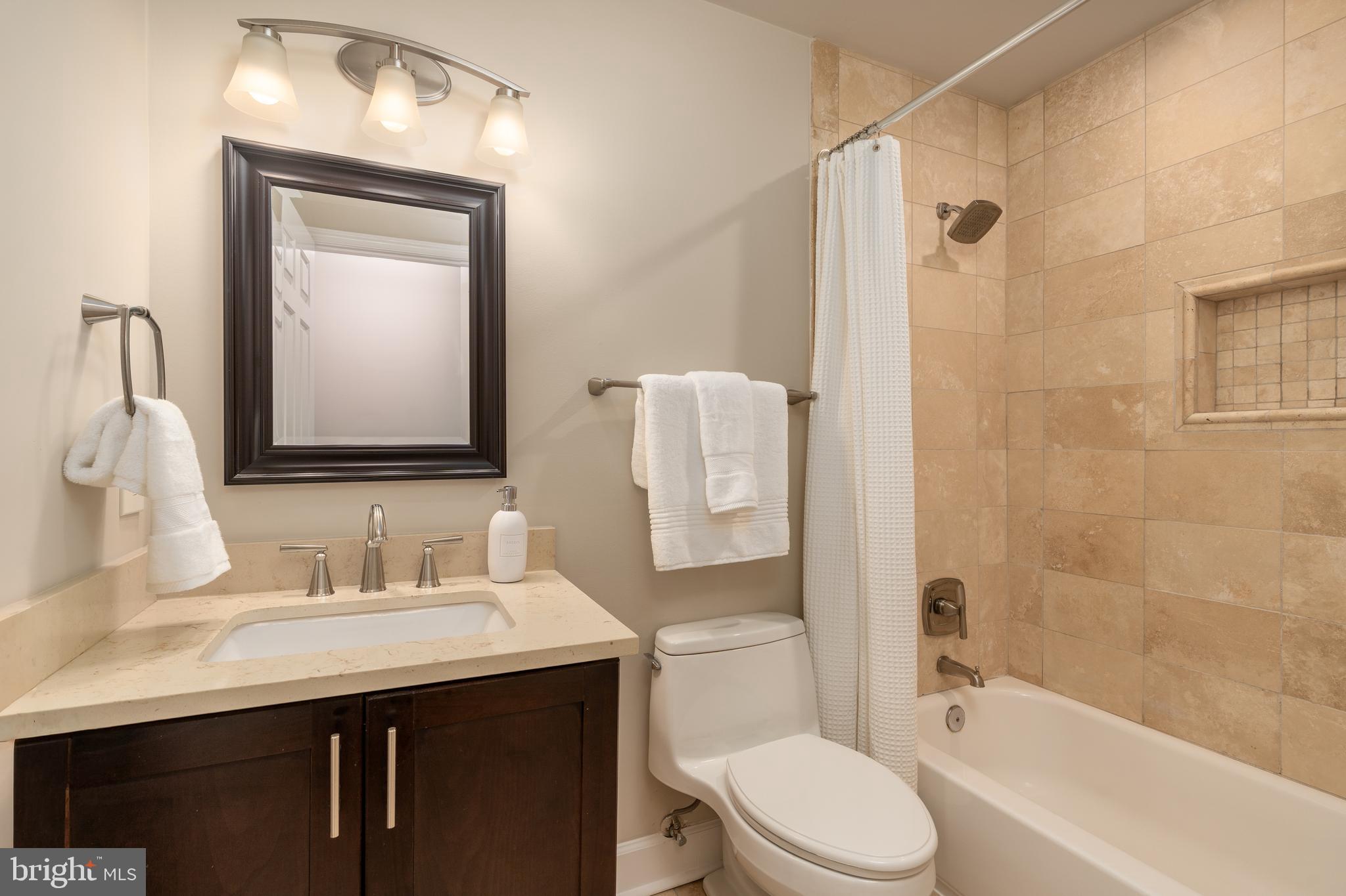 3299 Sutton Place Northwest, Unit C Washington, DC 20016 - Photo 29 of 41 a bathroom with a granite countertop toilet sink and mirror