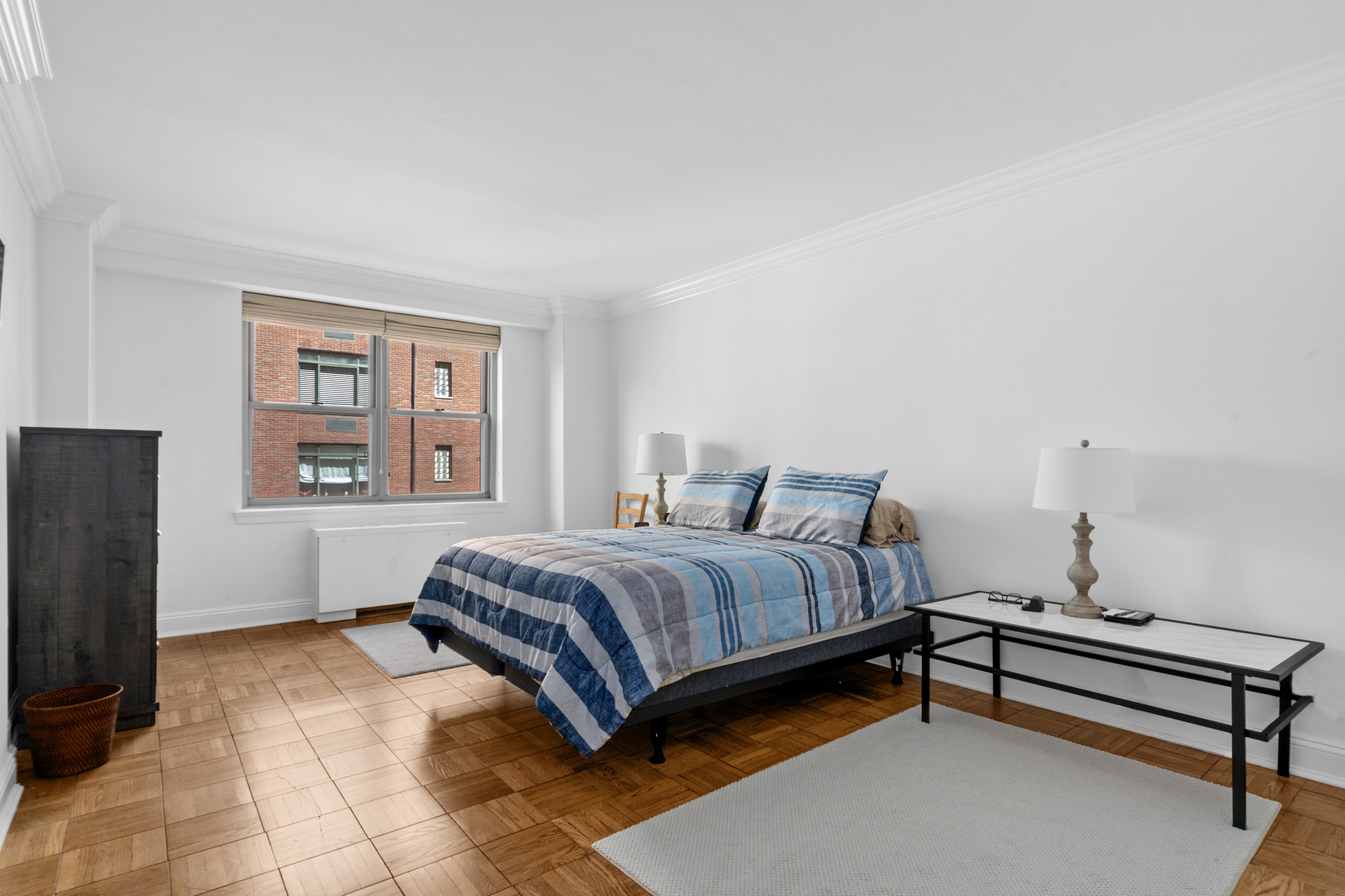 55 East 87th Street, Unit 5M Manhattan, NY 10128 - Photo 6 of 10 a bedroom with a bed and wooden floor