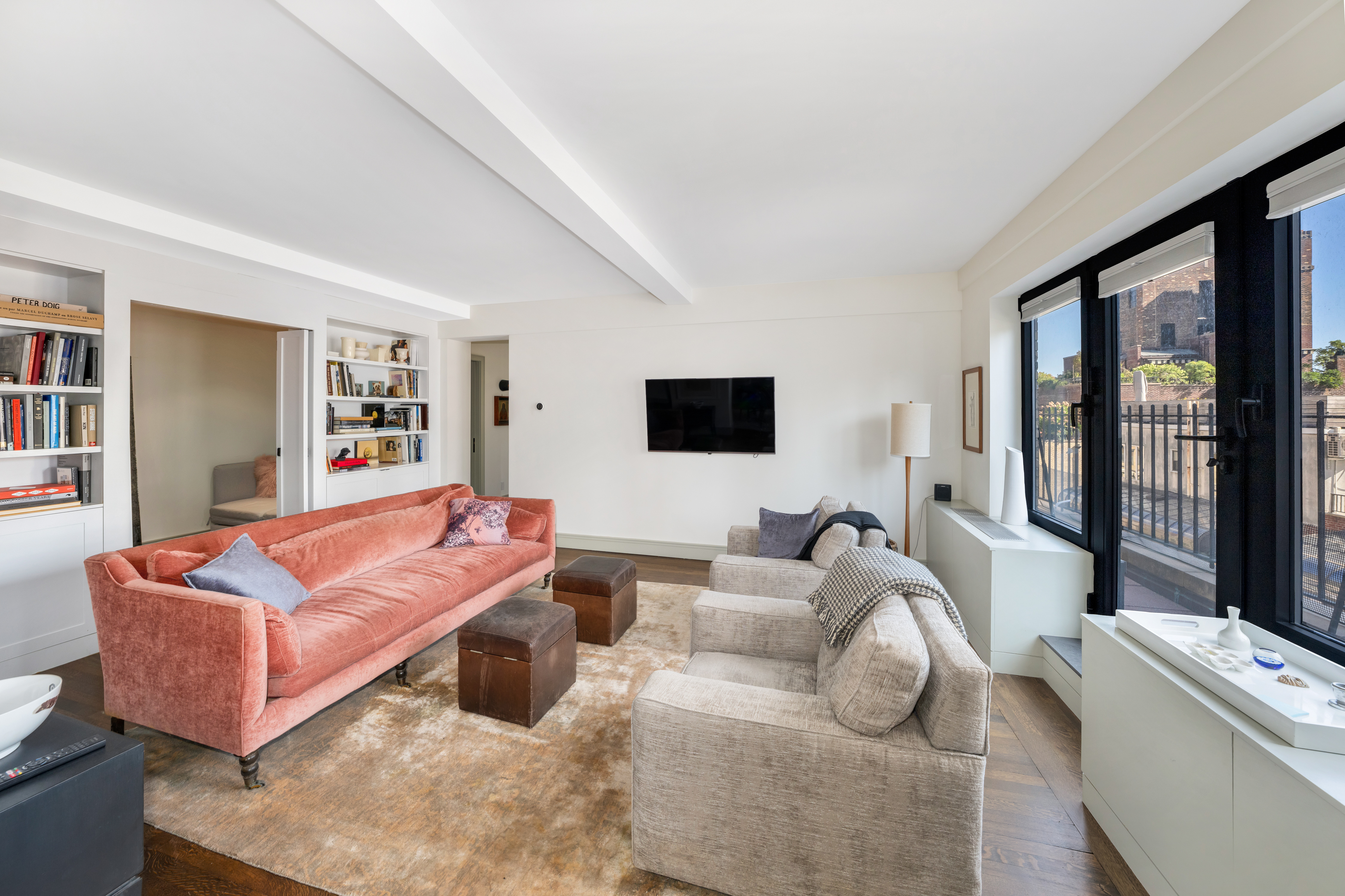 400 East 52nd Street, Unit 14J Manhattan, NY 10022 - Photo 2 of 11 a living room with furniture and a flat screen tv