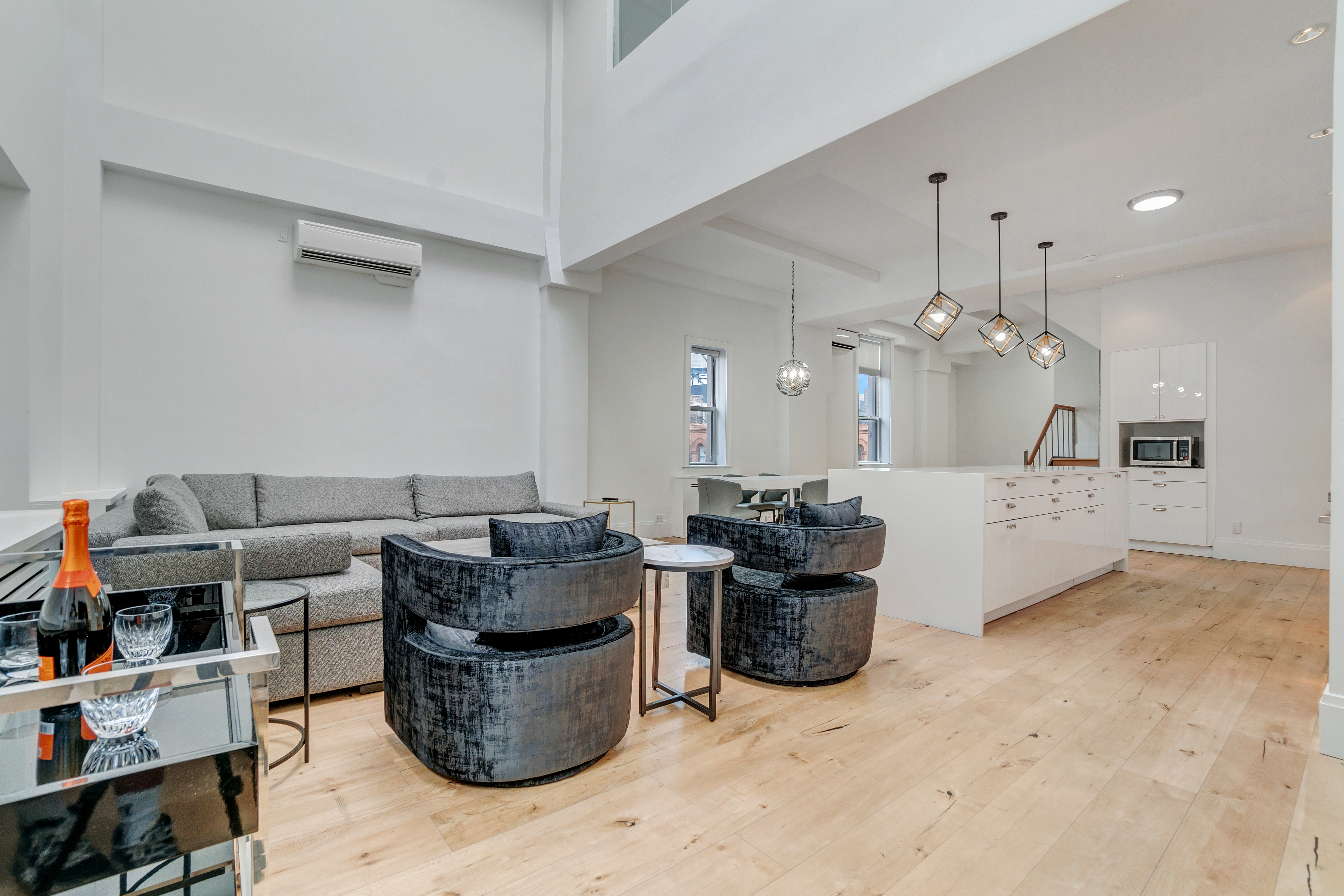 145 Spring Street, Unit PH Manhattan, NY 10012 - Photo 3 of 11 a living room with furniture and a chandelier