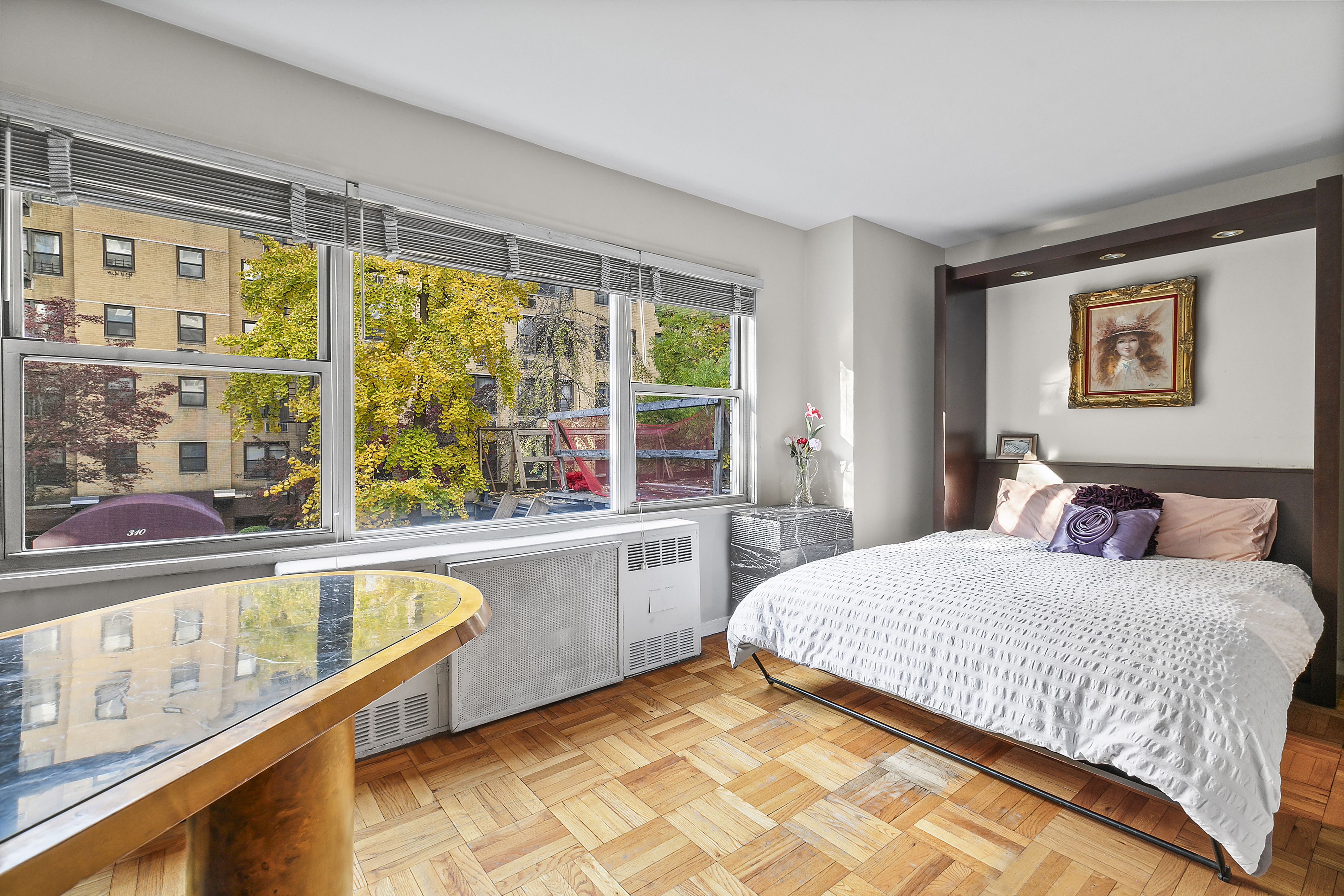 311 East 71st Street, Unit 2D Manhattan, NY 10021 - Photo 3 of 8 a bedroom with a large bed and a large window