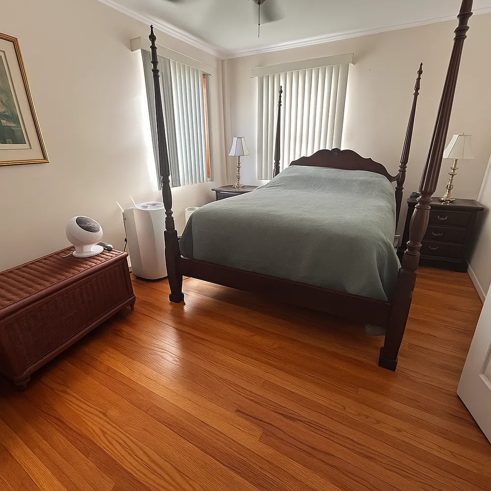 a bedroom with a bed and wooden floor