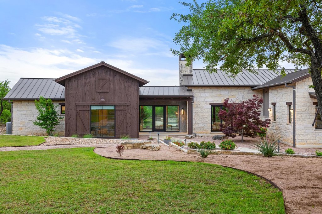2560 Bell Springs Road Dripping Springs, TX 78620 - Photo 16 of 42 a front view of a house with a yard table and chairs