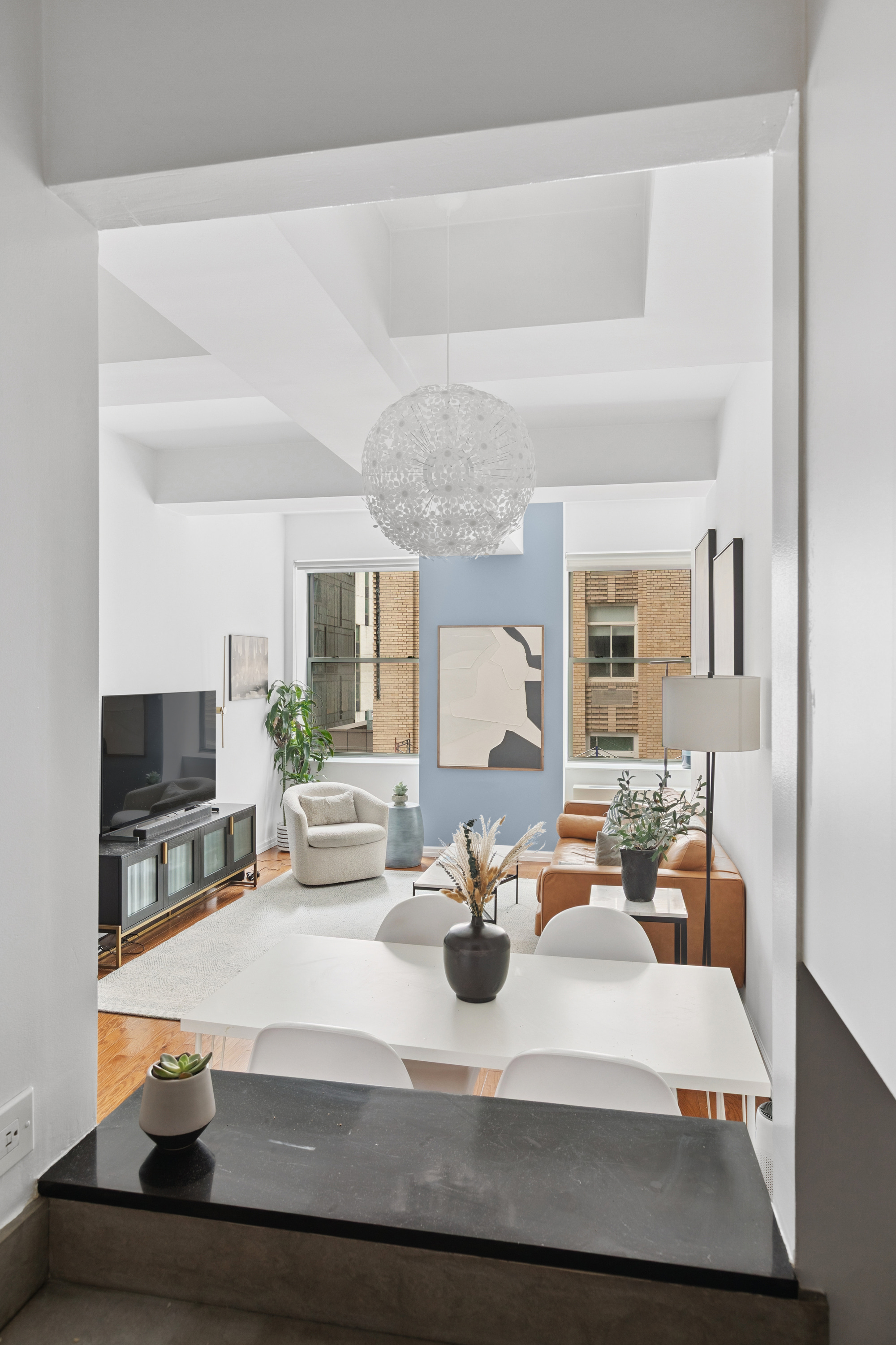 99 John Street, Unit 813 Manhattan, NY 10038 - Photo 4 of 20 a living room with furniture a flat screen tv and a fireplace