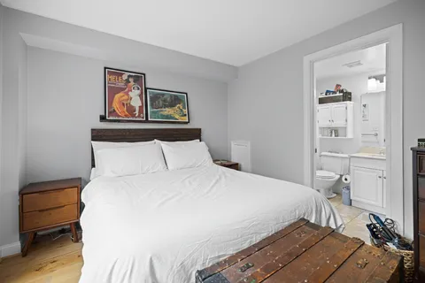 a bedroom with a bed and wooden floor