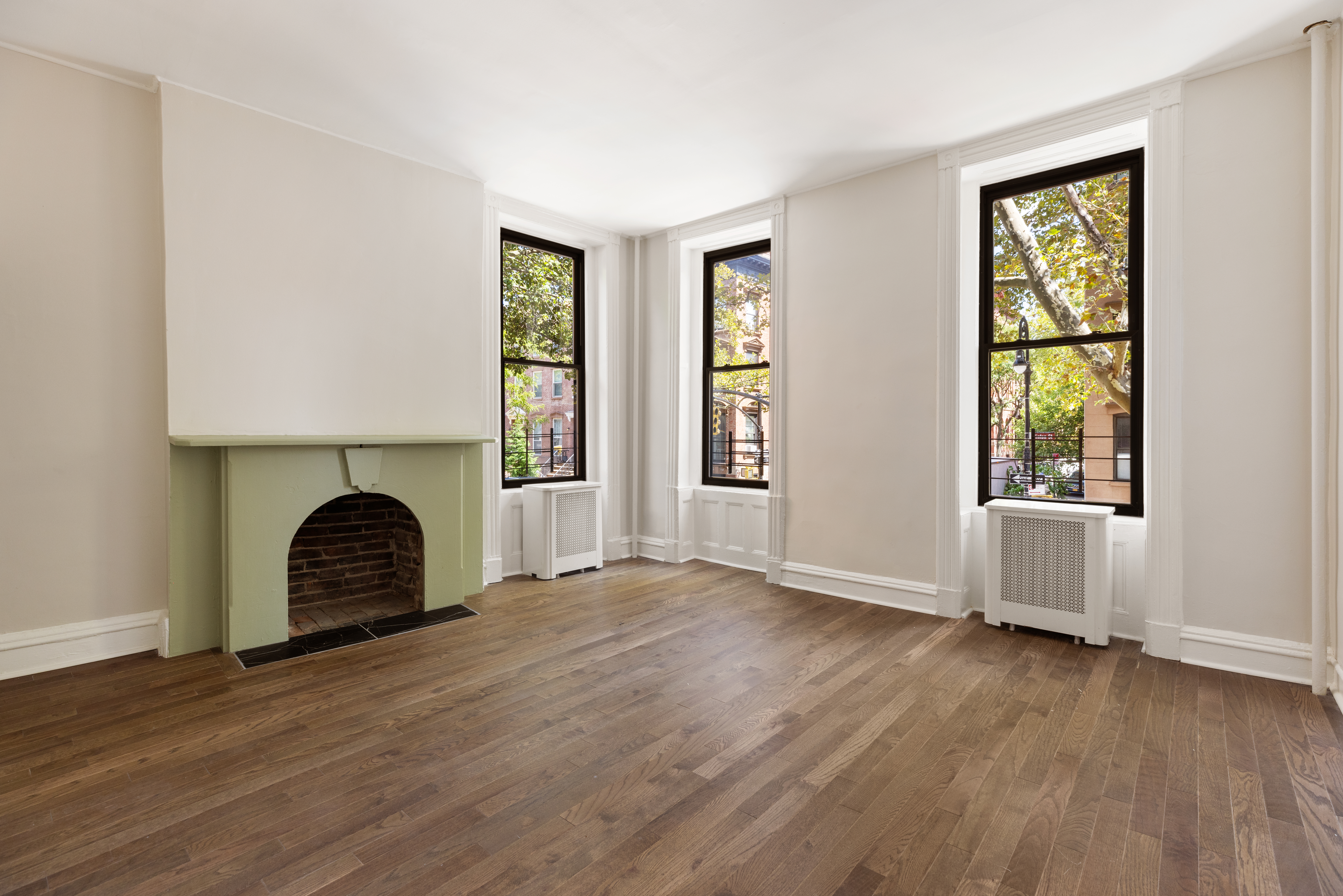 280 Clinton Street, Unit 1 Brooklyn, NY 11201 - Photo 5 of 11 an empty room with wooden floor fireplace and windows