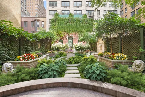 a front view of a house with a yard and fountain in middle