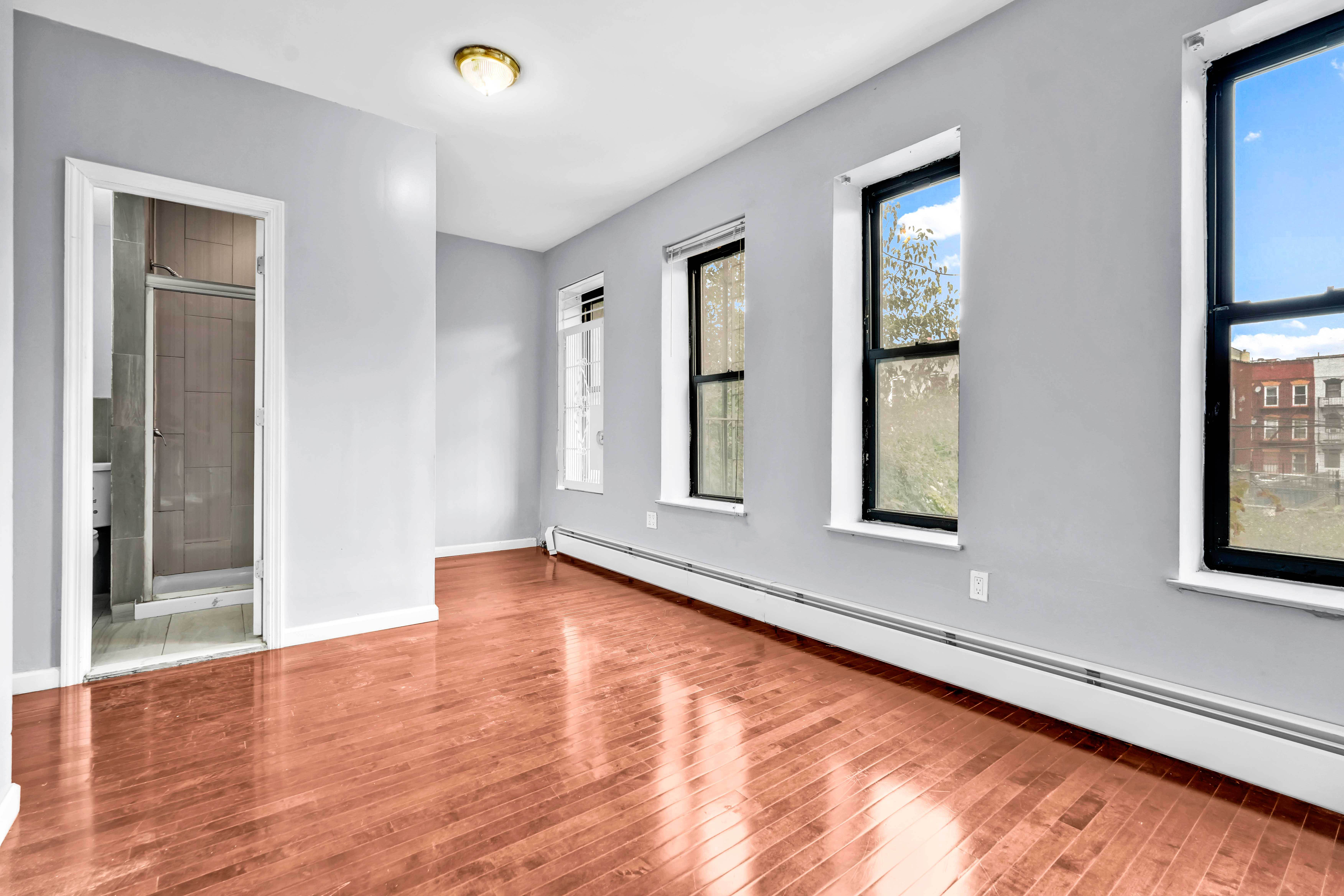 1633 St Johns Place, Unit 3 Brooklyn, NY 11233 - Photo 10 of 29 a view of an empty room with window and wooden floor