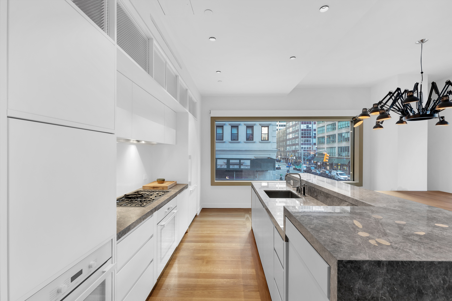 30 Warren Street, Unit 2C Manhattan, NY 10007 - Photo 3 of 18 a kitchen with granite countertop a sink and a stove top oven
