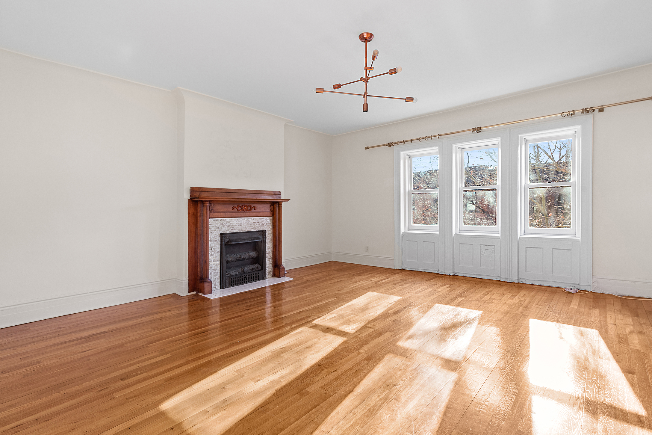 579 5th Street Brooklyn, NY 11215 - Photo 16 of 19 a view of an empty room with wooden floor fireplace and a window