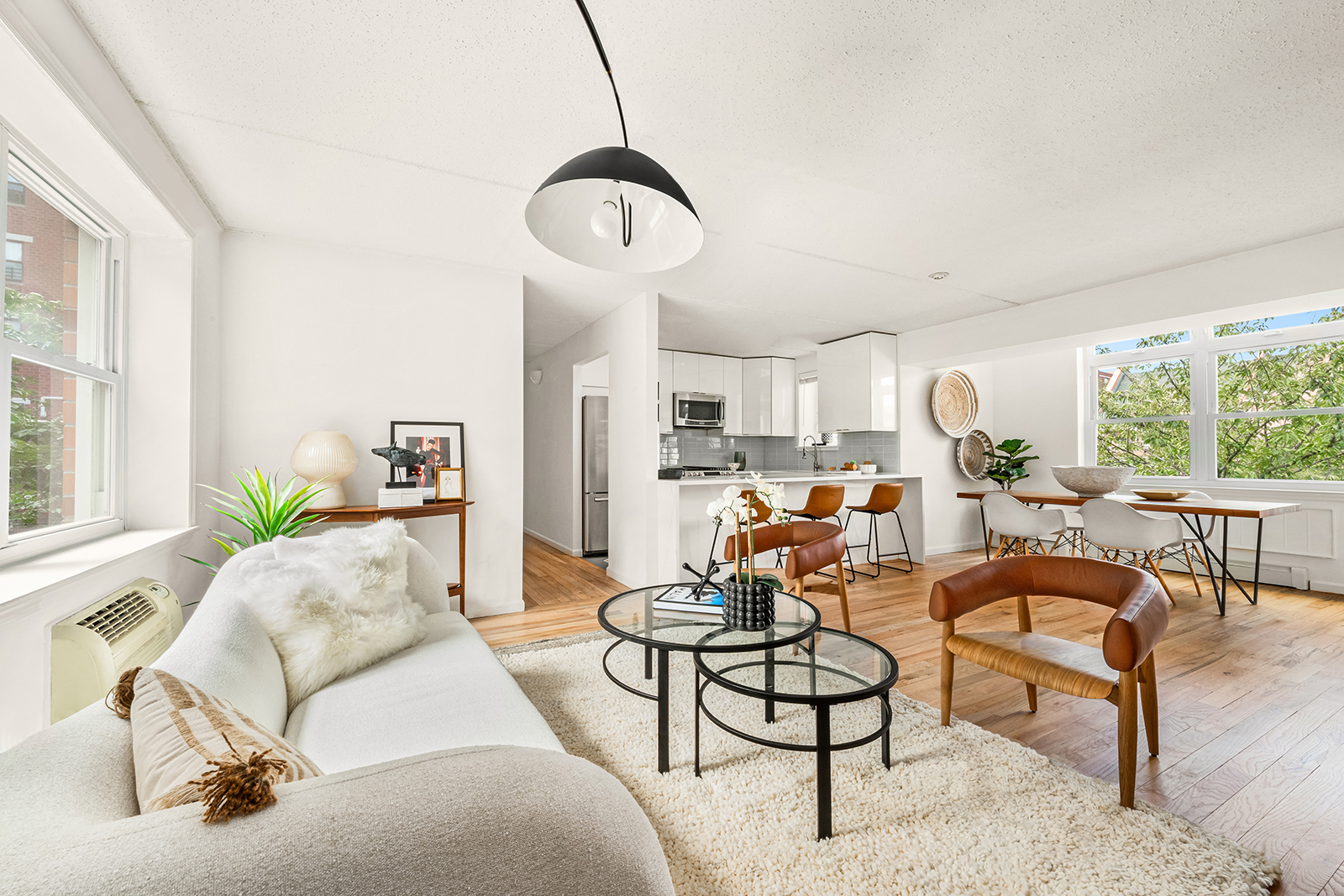 a living room with furniture kitchen view and a large window