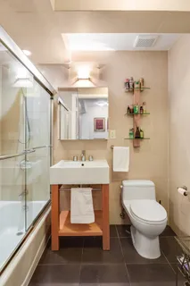 a bathroom with a granite countertop toilet sink and mirror