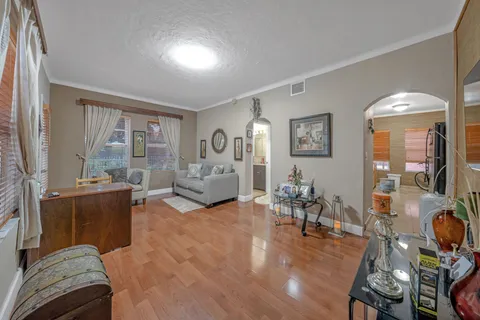 a view of a kitchen with kitchen island stainless steel appliances a stove a table and chairs in it