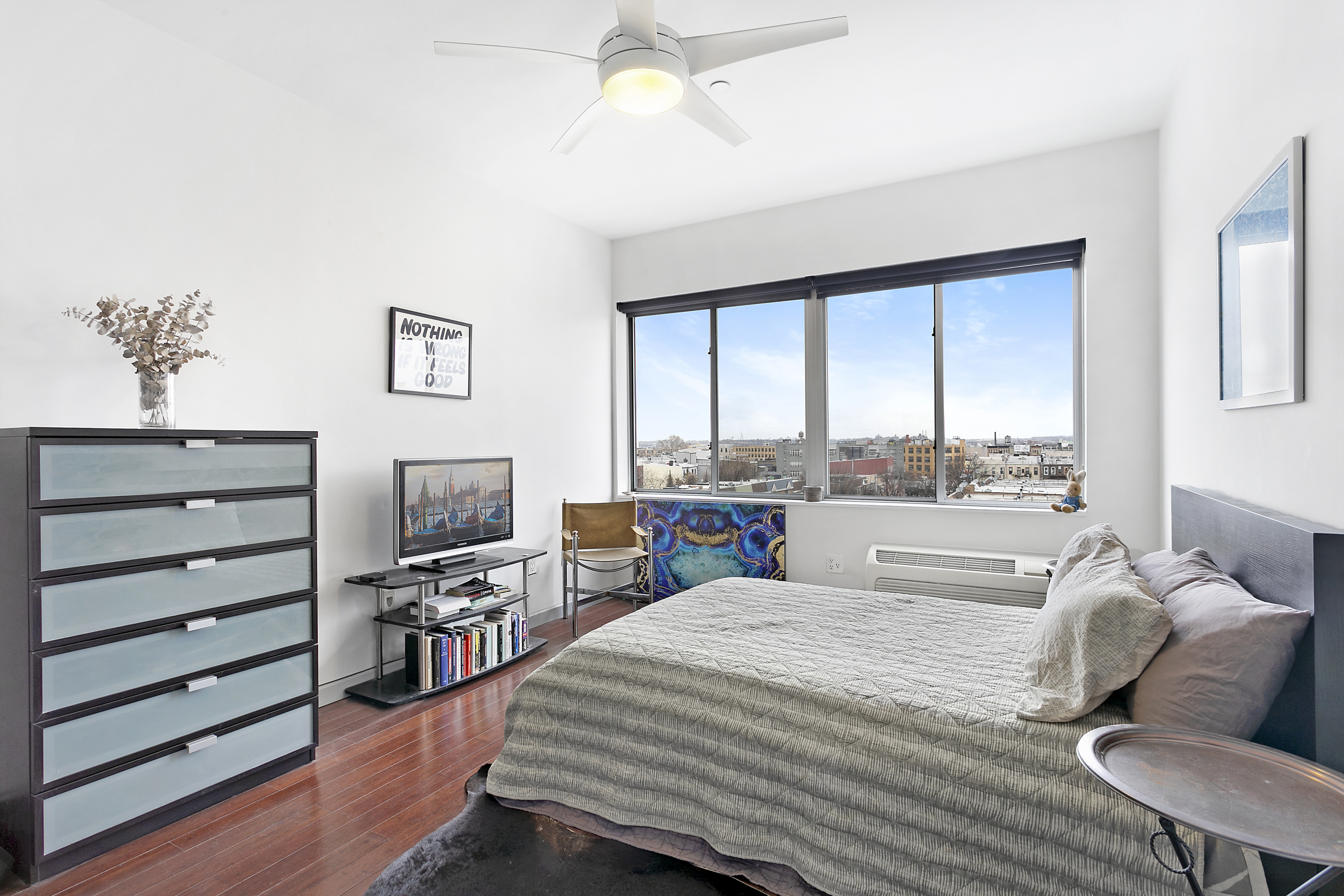 38 Wilson Avenue, Unit 4D Brooklyn, NY 11237 - Photo 2 of 10 a bedroom with a bed window and a flat screen tv