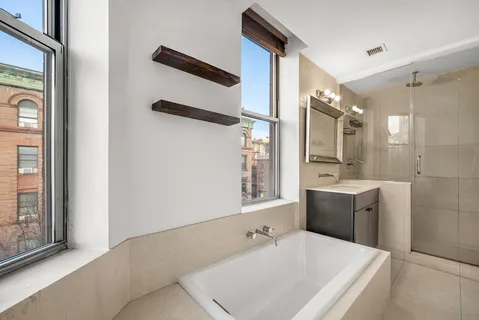 a bathroom with a tub sink and mirror