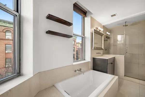 a bathroom with a tub sink and mirror