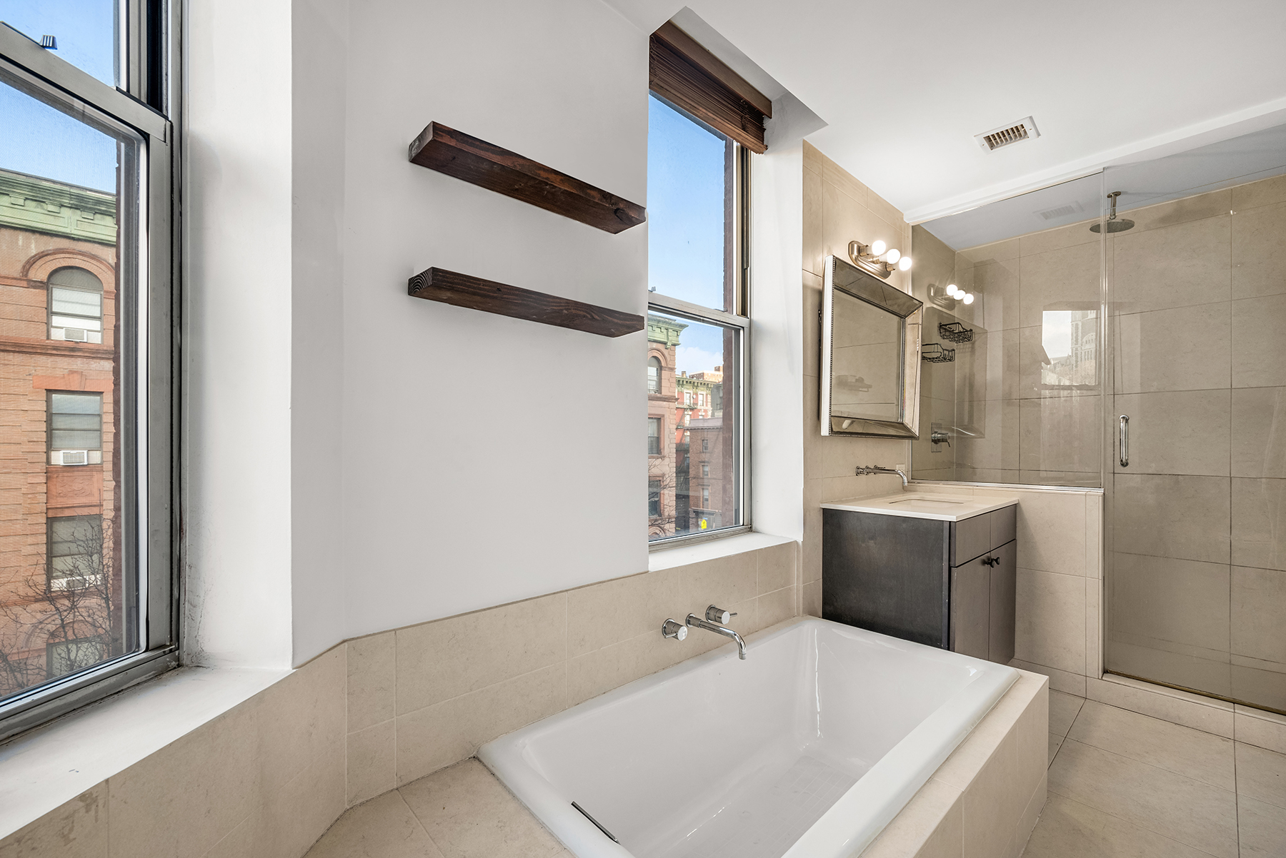 2605 Frederick Douglass Boulevard, Unit 4B Manhattan, NY 10030 - Photo 7 of 8 a bathroom with a tub sink and mirror