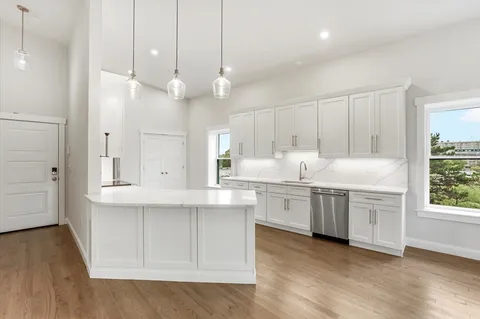 a kitchen with granite countertop white cabinets and white appliances
