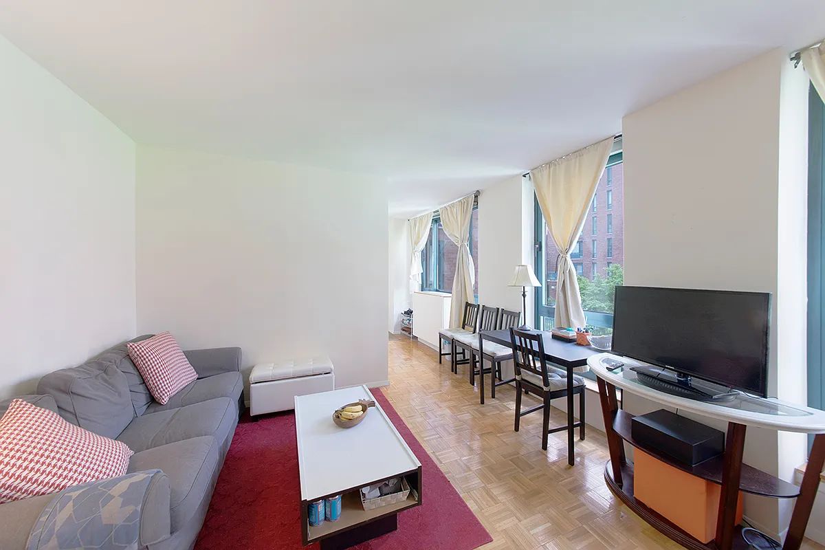 a living room with furniture a large window and a flat screen tv