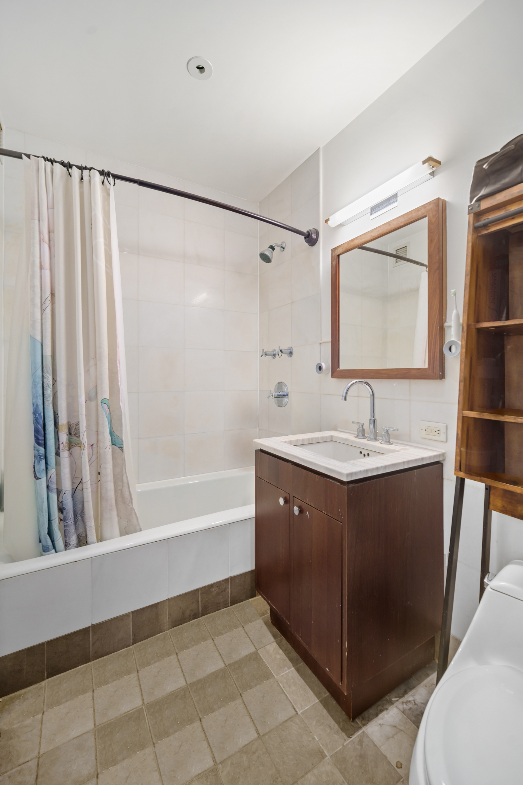 10 West End Avenue, Unit 11G Manhattan, NY 10023 - Photo 6 of 9 a bathroom with a bathtub sink and mirror