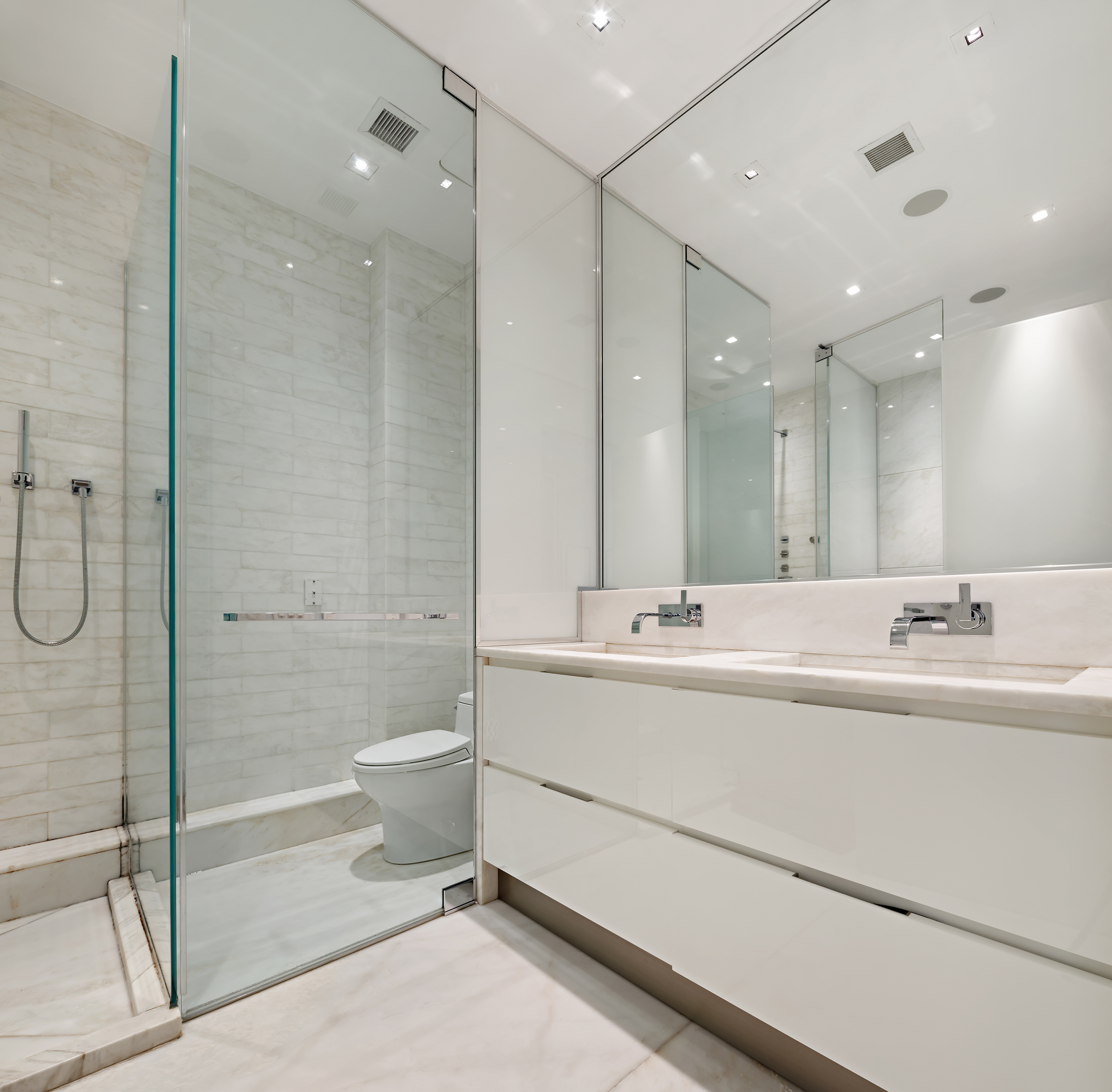1055 Park Avenue, Unit 1 Manhattan, NY 10028 - Photo 12 of 19 a bathroom with a double vanity sink toilet mirror and bathtub