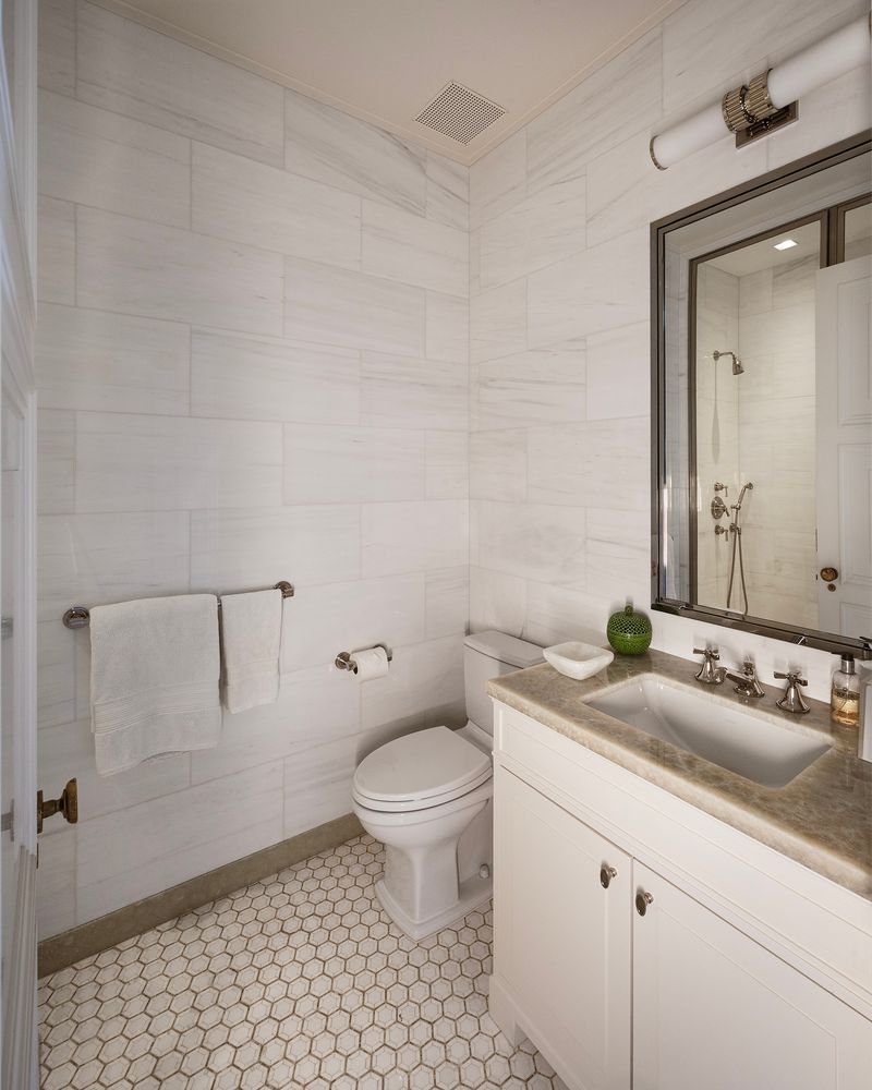 a bathroom with a granite countertop sink a toilet and a mirror