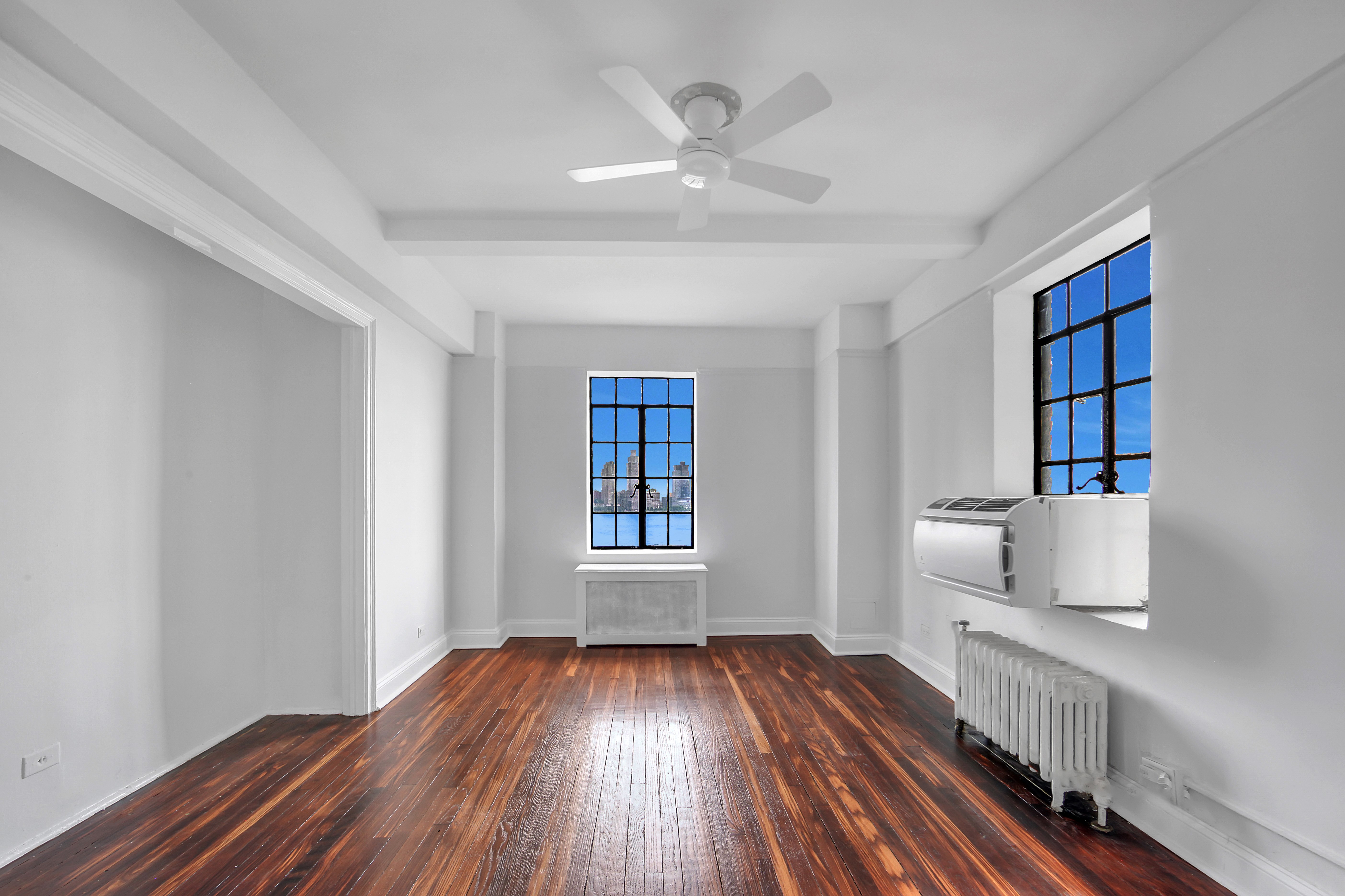 5 Tudor City Place, Unit 536 Manhattan, NY 10017 - Photo 2 of 14 wooden floor in an empty room with a window