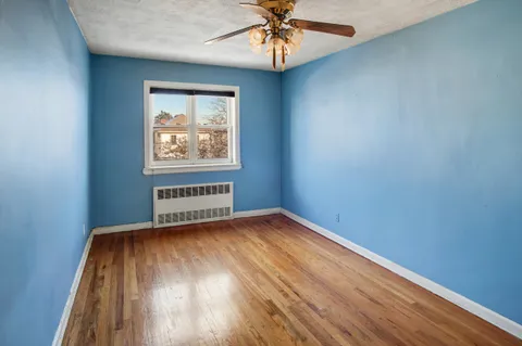 an empty room with a window and wooden floor