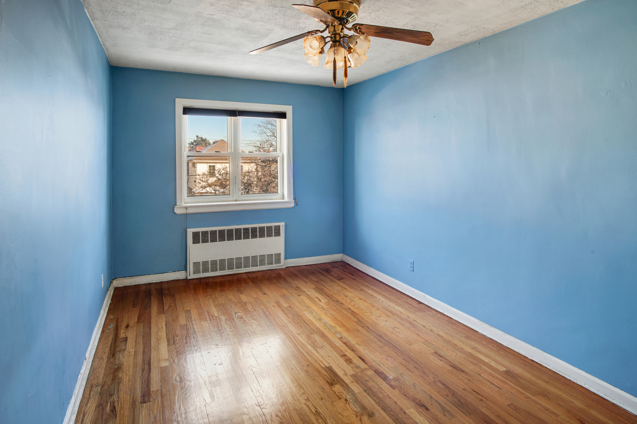 1986 West 13th Street Brooklyn, NY 11223 - Photo 8 of 11 an empty room with a window and wooden floor