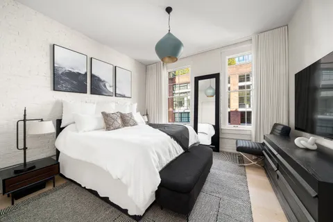 a bedroom with a bed and a flat screen tv