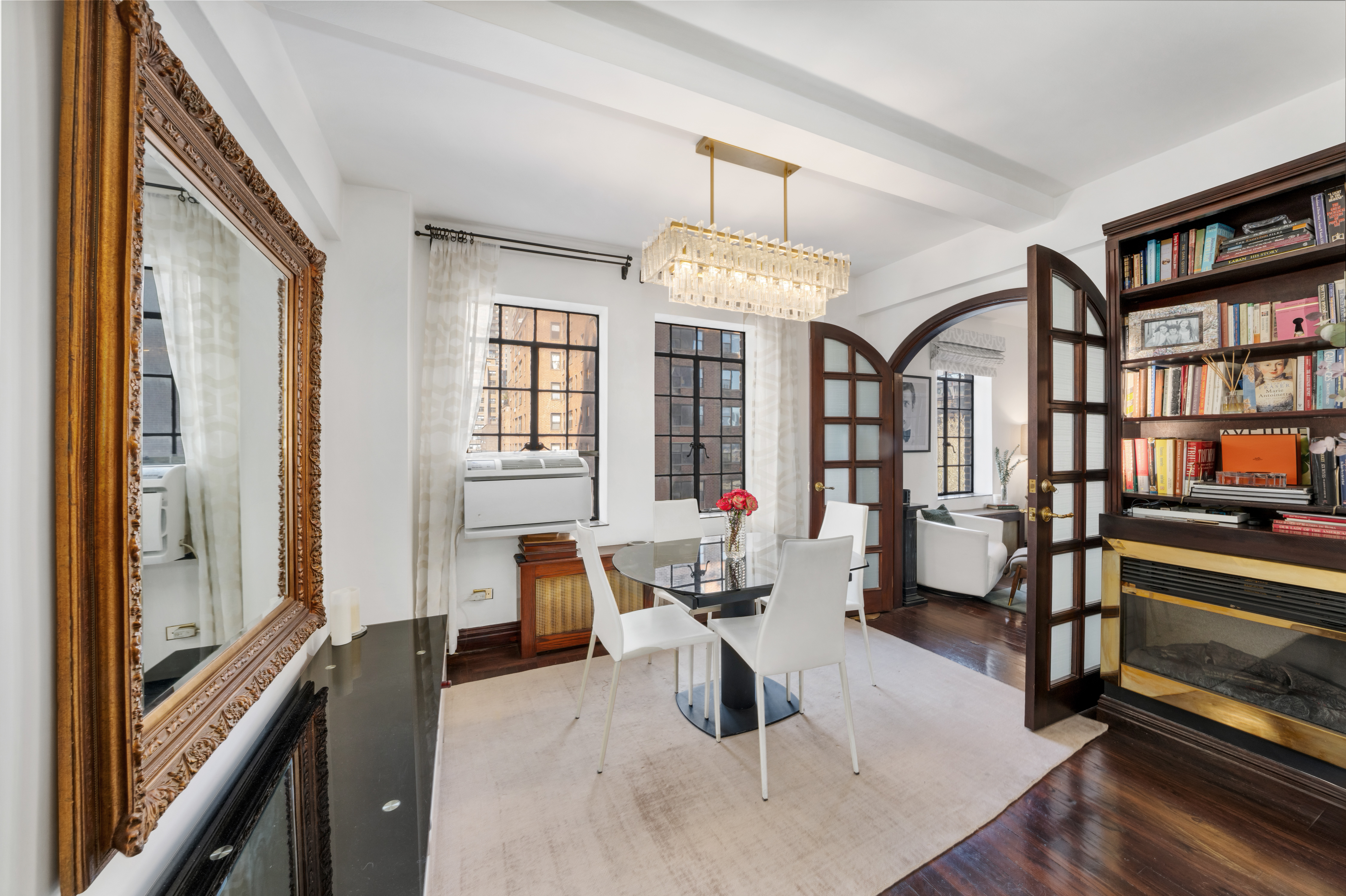 5 Tudor City Place, Unit 811 Manhattan, NY 10017 - Photo 6 of 14 a living room with furniture and a chandelier