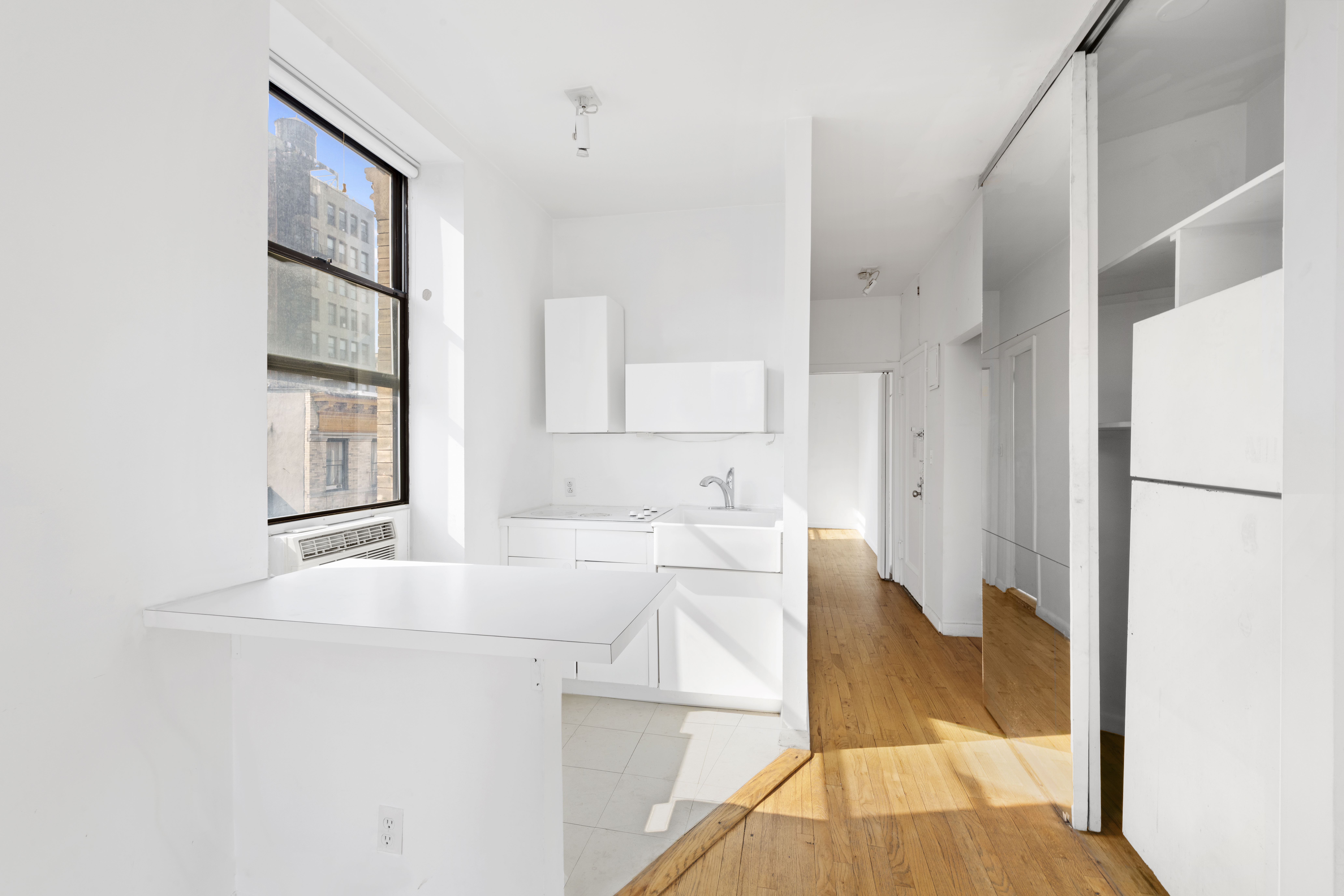 214 Mulberry Street, Unit 6B Manhattan, NY 10012 - Photo 5 of 12 a kitchen with granite countertop a refrigerator and a sink
