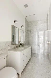 a bathroom with a granite countertop sink mirror and toilet
