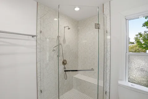 a bathroom with a shower and a glass door