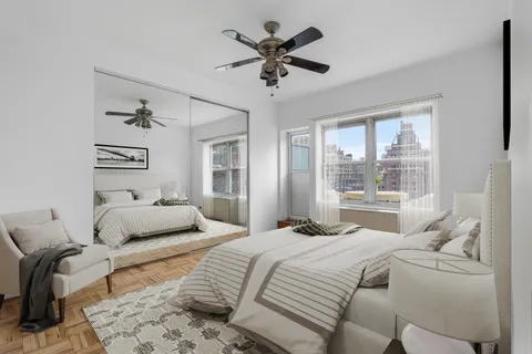 a bedroom with a bed couches and white walls