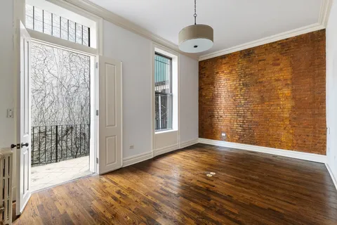 a living room with stainless steel appliances wooden floor and large window