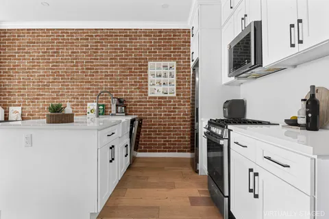 a kitchen with stainless steel appliances a stove refrigerator sink and cabinets