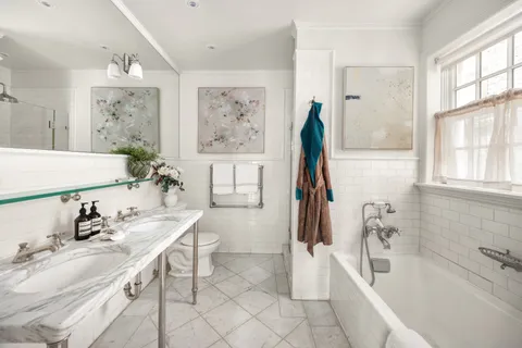 a bathroom with a tub sink and mirror