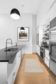 a kitchen with stainless steel appliances granite countertop a sink and a refrigerator
