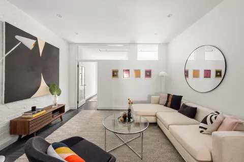 a living room with furniture and a mirror