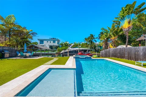 a view of a swimming pool with a bench and trees in the background